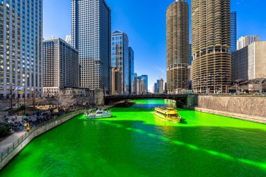 Chicago, Illinois, Usa 'daki yeşil renkli nehri boyayan Şikago nehri çevresindeki Aziz Patrick gününde Chicago' daki bina ve şehir manzarası taçlandırılmış İrlandalıları ve Amerikan halkını kutluyor..