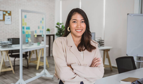 Portrait of Asian Business woman with Arms Crossed and standing at modern workplace, human resource and small business owner, hiring new employee, business person concep