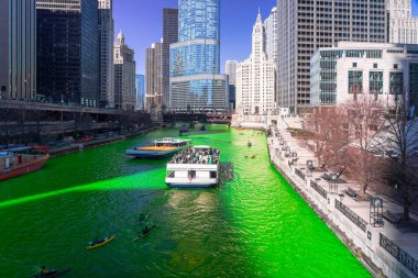 Chicago, Illinois, Usa 'daki yeşil renkli nehri boyayan Şikago nehri çevresindeki Aziz Patrick gününde Chicago' daki bina ve şehir manzarası taçlandırılmış İrlandalıları ve Amerikan halkını kutluyor..