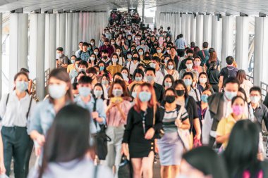 BANGKOK, THAILAND - MAR 2020: 18 Mart 2020 'de Bangkok taşımacılığında yoğun iş saatlerinde Coronavirus salgınını önlemek için cerrahi maske takan tanınmamış iş adamlarından oluşan bir kalabalık