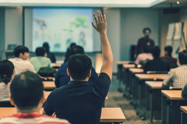 后视镜观众在会议室或会议室举手回答问题 而亚洲人在舞台 研讨会 商业和教育理念等方面的发言 — 图库照片