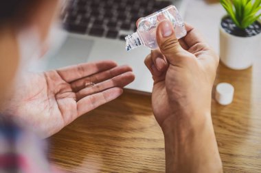 İş bitmeden önce el dezenfektanı jel pompası kullanan Asyalı adam.