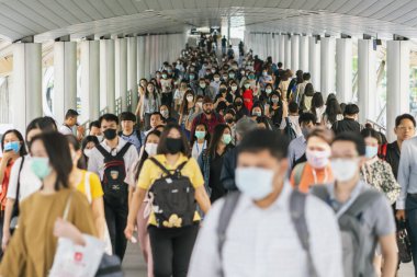BANGKOK, THAILAND - MAR 2020: 18 Mart 2020 'de Bangkok taşımacılığında yoğun iş saatlerinde Coronavirus salgınını önlemek için cerrahi maske takan tanınmamış iş adamlarından oluşan bir kalabalık