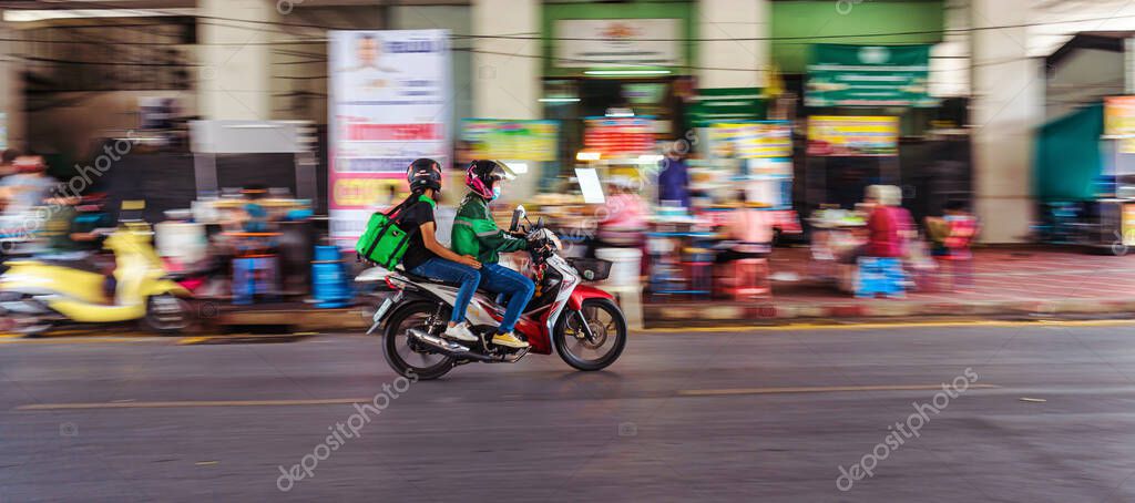 BANGKOK, THAILAND - APRIL 2020 : Motion blur of Grab Food Bikers riding the motorcycle to service Food delivery on April 17,2020,Bangkok,Thailand.Covid19 outbreak Making food delivery services Popular