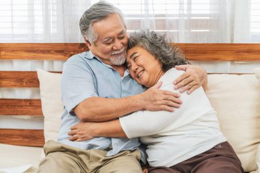 Asyalı çift, büyük ebeveyn, evde mutlu bir şekilde kucaklaşıyor ya da sarılıyor. Sevgililer Günü ya da sevgililer günü veya sevgilileri, çok yaşa ve yaşlılar topluluğu, sıcak aile ve mutluluk kavramı.