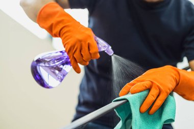 Asyalı adam, virüse karşı korunma, sosyal uzaklık ve karantina konsepti ile sorumlulukların korunması, salgın ve salgın hastalıklar, salgın hastalıklar ve salgın hastalıklar için ev merdivenlerine püskürtüyor.