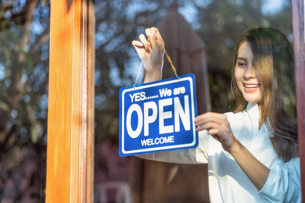 コーヒーショップへのお客様を歓迎するために店のメガネでオープンサインを設定するアジアの若いアジアの女性 カフェショップで小さなビジネスオーナーとスタートアップ オープンと近いラベルコンセプトをインストールします — ストック写真