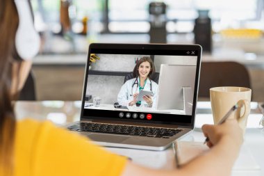 Koronavirüs salgını, Covid-19 salgını, çevrimiçi yetişkin danışmanlığı ve yeni normal bir konsept ortaya çıktığında hastalığın devamı için doktorla görüşen Asyalı İş kadını.