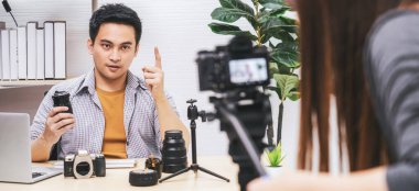Kamerayı çeken ve Asyalı Vlogger 'ın dizüstü bilgisayarıyla canlı olarak kameranın lenslerini tatmin eden kamera, sosyal medya kanalı, vlog ve Influencer konsepti ile izleyicilere bilgi aktarıyor.
