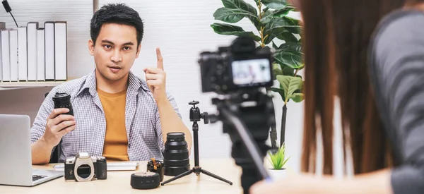 Camera taking video and live with laptop of Asian Vlogger man satisfied the camera lens each media, sharing knowledge to audience via camera by social media channel,vlog and Influencer concept