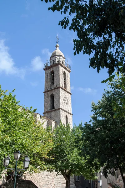 Věž kostela v Sartene, Korsika s moderní hodiny — Stock fotografie