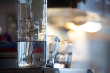 Odaklanan şişe ve bir bardak su Buzdolabının kenarında bulanık.