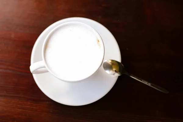 Une tasse de café sur une table en bois. Cappuccino. Lumières sur le fond. Vue du dessus . — Photo