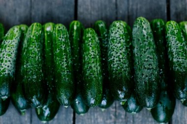 Ahşap yüzeyde salatalıklar. Mevsimlik sebzeler. Taze sebzeler. Sağlıklı beslenme.