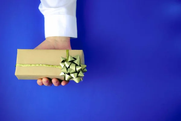 Male hand holding gift box.