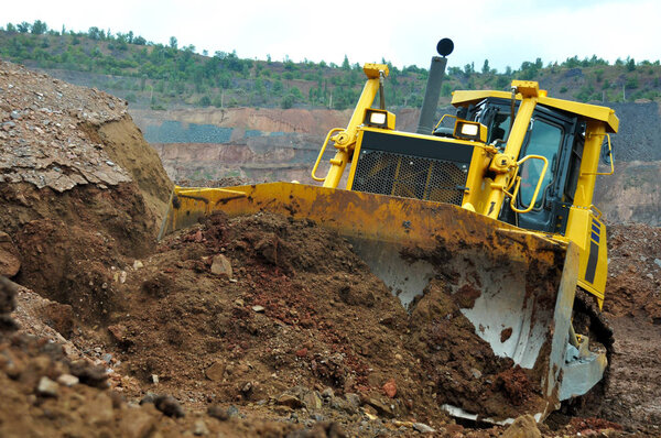 track-type loader bulldozer excavator machine doing earthmoving work at  quarry