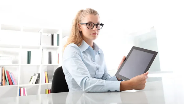 Mujer mostrando tableta sentado en el escritorio — Foto de Stock