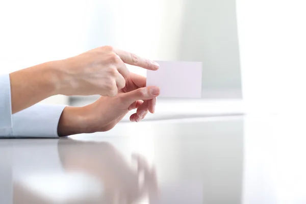Hand hält leere Visitenkarte, auf dem Schreibtisch — Stockfoto
