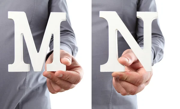 Händer som håller bokstaven M och N från alfabetet isolerad på en vit b — Stockfoto