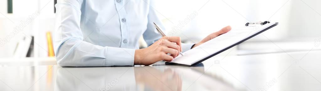 woman hands writing on clipboard with a pen, isolated on desk pa