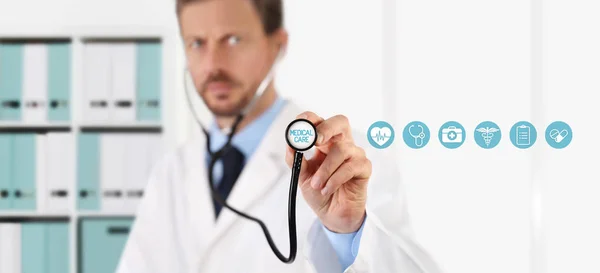 Arzt mit Stethoskop in den Händen und medizinischen Ikonen auf dem Schoß — Stockfoto