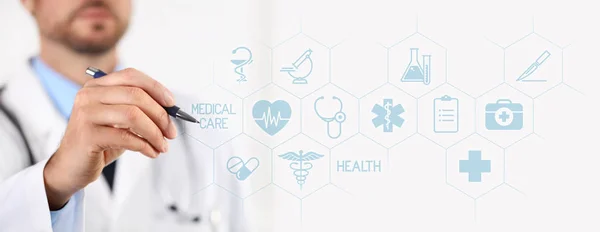 Arzt mit Stift, der medizinische Symbole auf Touchscreen zeigt — Stockfoto