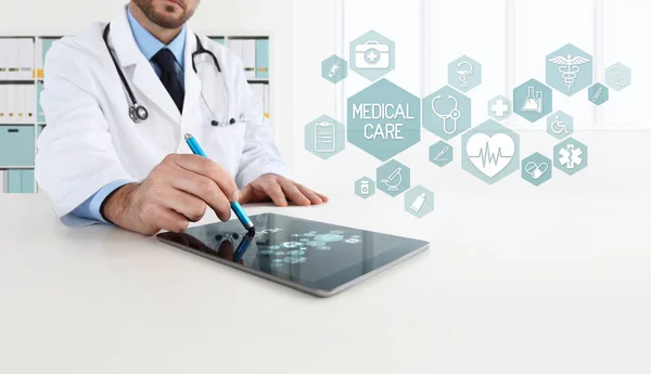 Arzt verwendet Tablet mit Symbolen im Büro — Stockfoto