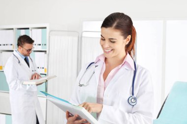 Doktor tıbbi belgelerle gülümseyen
