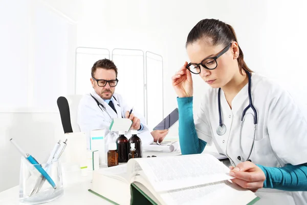 Arzt verschreibt Rezept mit Tablette und Krankenschwester lesen — Stockfoto