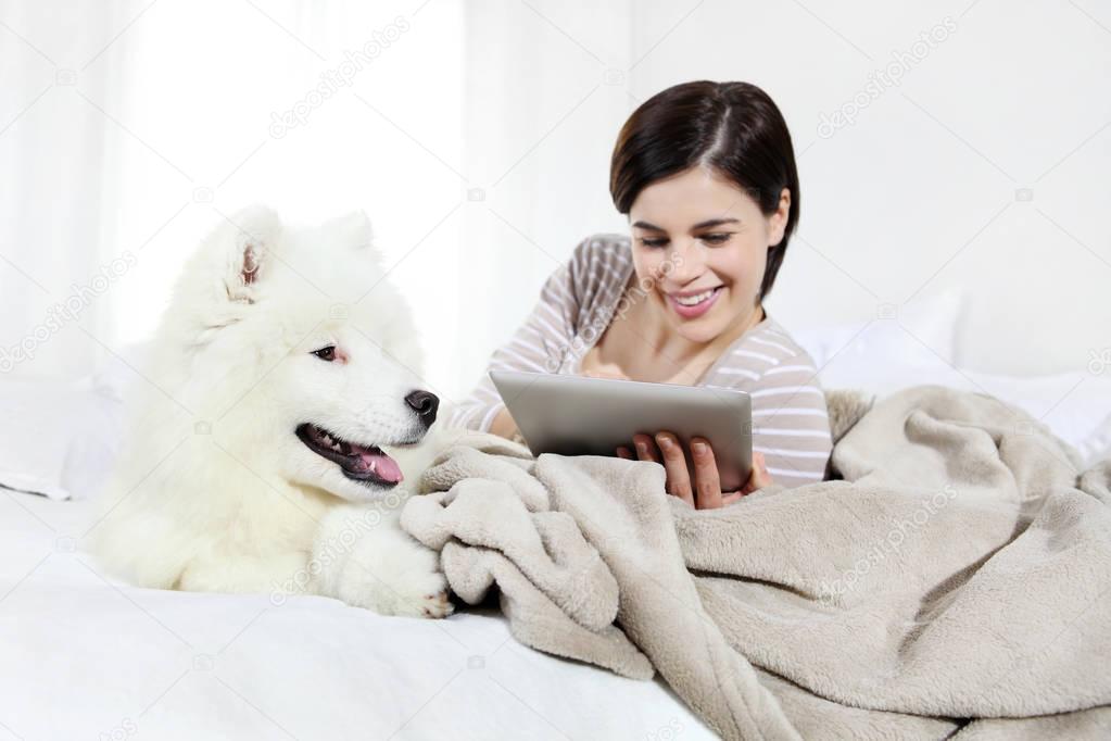 smiling woman with pet dog and tablet