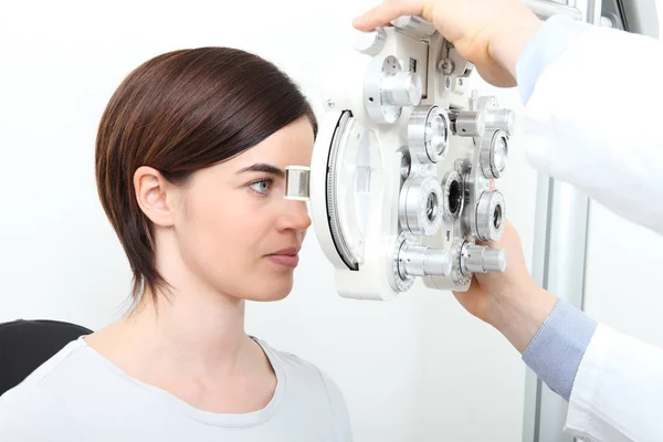 Mujer haciendo medición de la vista con phoropter óptico — Foto de Stock