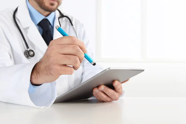 Lékař pomocí digitálních tabletu na stole — Stock fotografie
