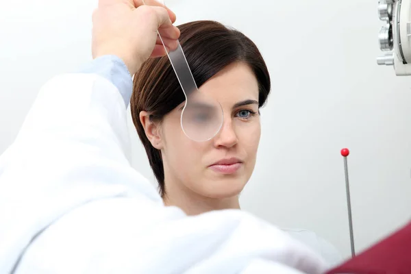 Optometrista médico óptico examina la vista de la mujer paciente i — Foto de Stock