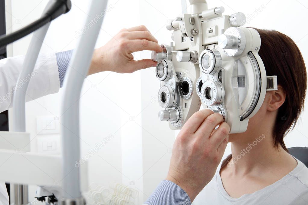 woman doing eyesight measurement with optical phoropter