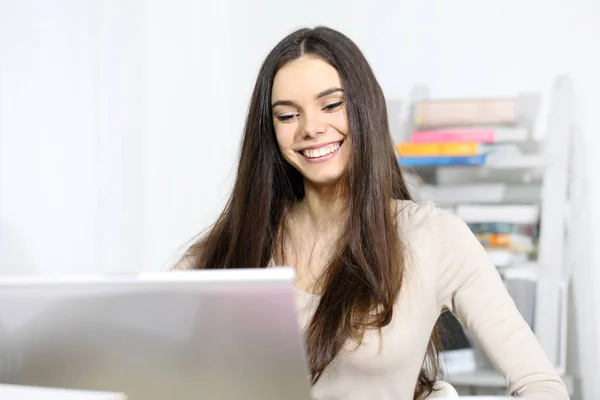 Улыбающаяся молодая женщина перед компьютером, счастливые сообщения — стоковое фото