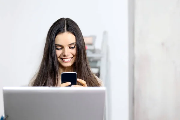 Sorrindo mensagem de texto jovem mulher, usando celular na frente de — Fotografia de Stock