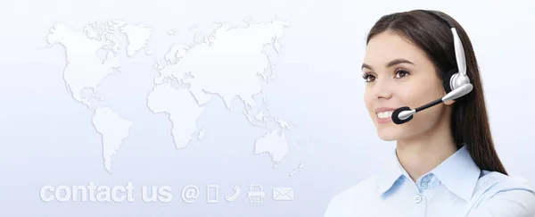 Operadora de servicio al cliente mujer con auriculares sonriendo, mapa del mundo —  Fotos de Stock