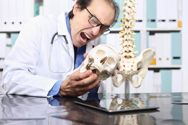 Сумасшедший доктор с черепом в офисе, безумная концепция — стоковое фото