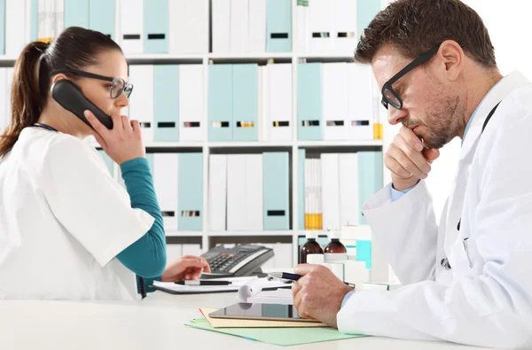 Orvos-val a tabletta és a nővér telefon-ban orvosi rendelő — Stock Fotó