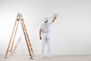 Dikiz ressam adam arıyor ve boş duvar boyama