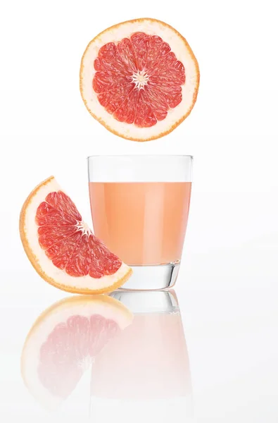 葡萄柚汁中分离出白色背景上的玻璃 — 图库照片