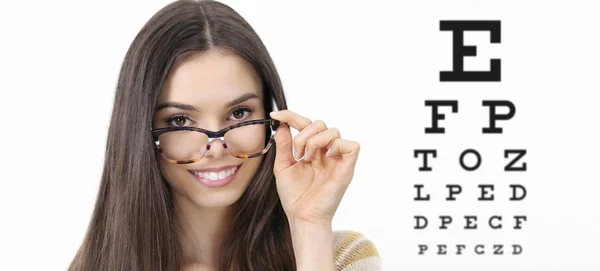 Sorriso rosto feminino com óculos na visão fundo gráfico teste, oftalmologia exame oftalmológico conceito — Fotografia de Stock