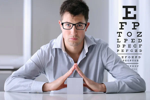 Manliga ansikte med glasögon på syn test diagrammets bakgrund, öga — Stockfoto