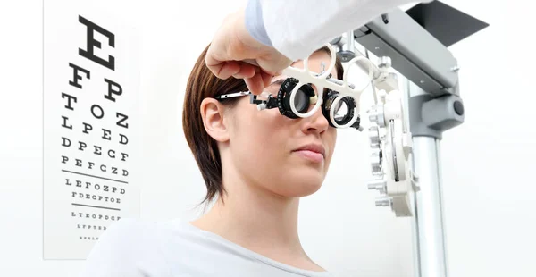 Mujer haciendo medición de la vista con marco de prueba y visual tes — Foto de Stock