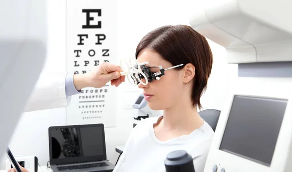 Mujer haciendo medición de la vista con marco de prueba y visual tes — Foto de Stock