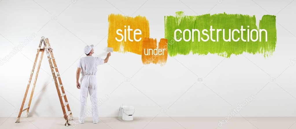 painter man with paint brush drawing under construction text iso