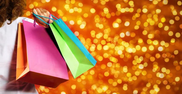 Weihnachtseinkäufe, Frau mit Taschen auf verschwommenem hellen Licht bac — Stockfoto