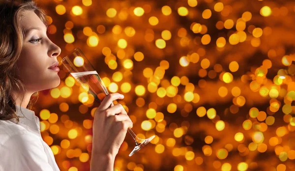 Christmas theme, woman drinks a glass of sparkling wine on blurr — Stock Photo, Image