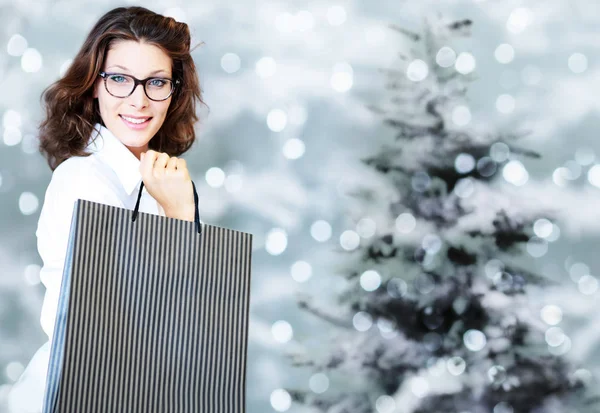 Karácsonyi bevásárlás, mosolygós nő táskákkal a homályos világos li — Stock Fotó