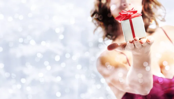 Presente de Natal presente, mulher com pacote em lig brilhante borrado — Fotografia de Stock